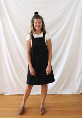 Ethically made pinafore style dress in black linen with one pocket. Mid length and short.