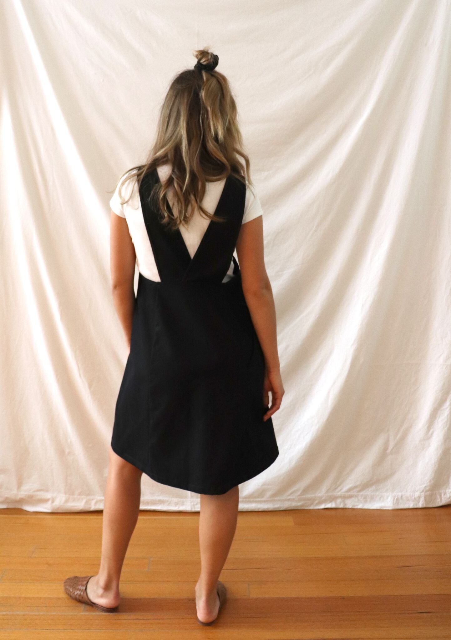 Ethically made pinafore style dress in black linen with one pocket. Mid length and short.