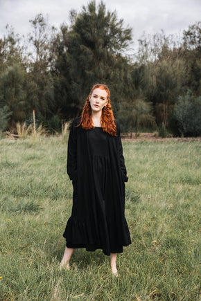 Ethically made long coat with side pockets and waist-tie in black cotton linen mix.