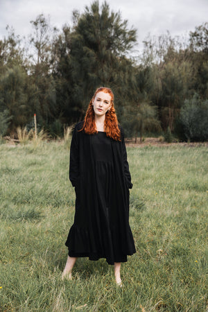 Ethically made long coat with side pockets and waist-tie in black cotton linen mix.